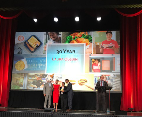 Laura Olgin on stage for her 30 year award as a franchise owner.
